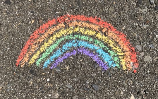 Mit Kreide gemalter Regenbogen auf Asphalt