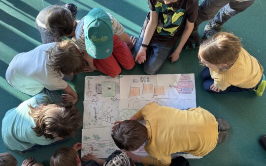 Kinder untersuchen eine gemalte Schatzkarte mit einem roten "X", wo der Schatz versteckt sein soll.